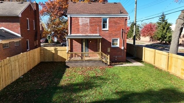 rear view of property with a lawn