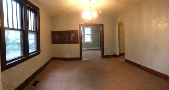 spare room with carpet floors and a notable chandelier