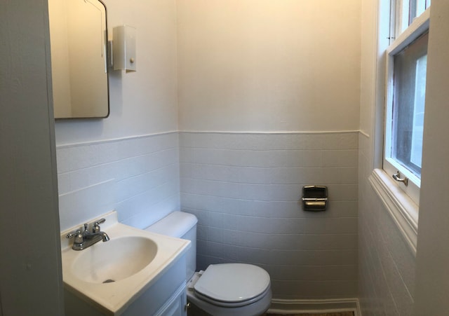 bathroom with vanity, tile walls, and toilet