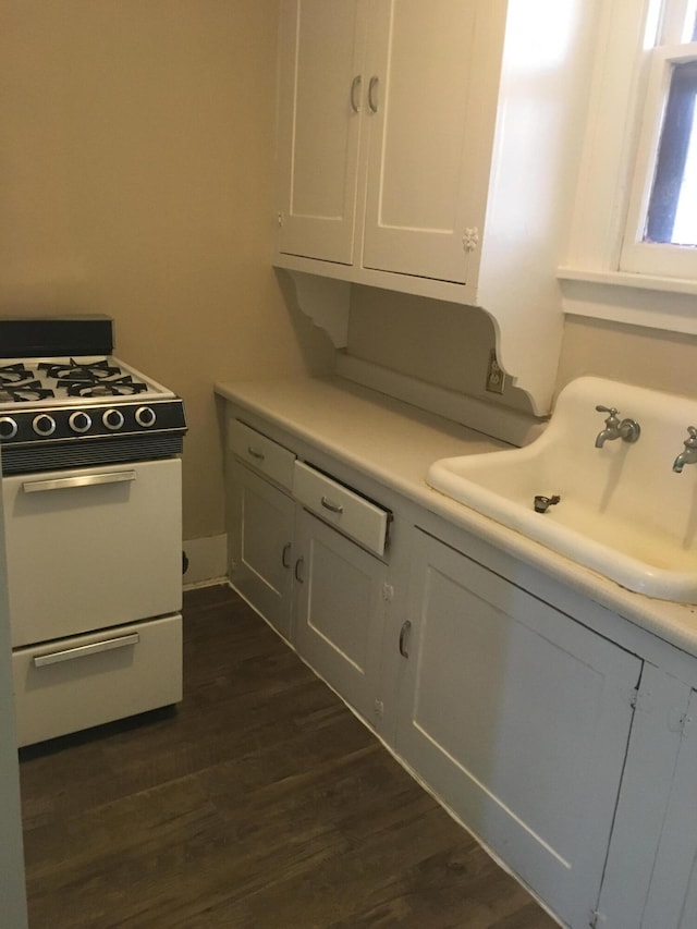 kitchen featuring white cabinetry, gas range gas stove, sink, and dark wood-type flooring