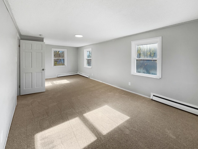 carpeted spare room with a textured ceiling, crown molding, a wealth of natural light, and a baseboard heating unit