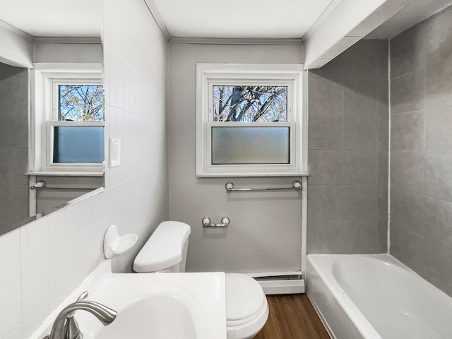 bathroom featuring tile walls, wood-type flooring, a baseboard heating unit, and toilet