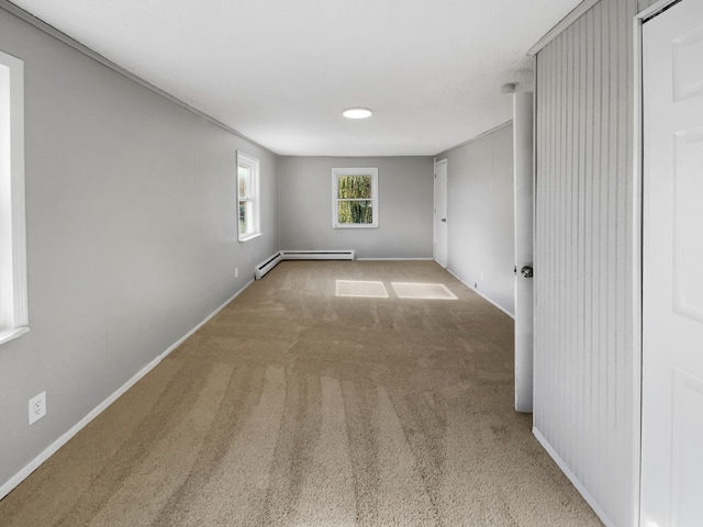 empty room featuring baseboard heating and light carpet