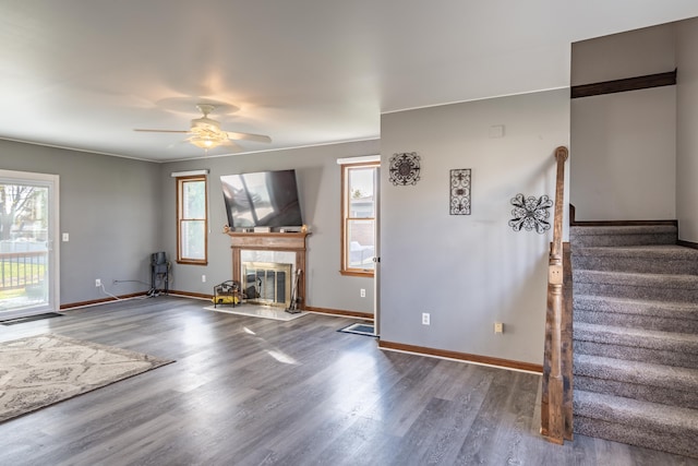 unfurnished living room featuring hardwood / wood-style flooring, a tiled fireplace, plenty of natural light, and ceiling fan