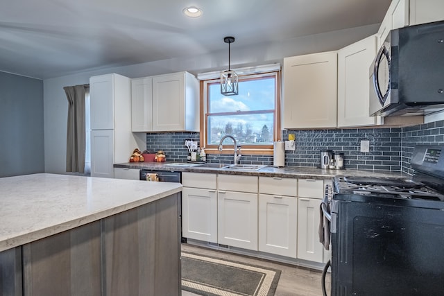 kitchen featuring sink, backsplash, decorative light fixtures, white cabinets, and appliances with stainless steel finishes