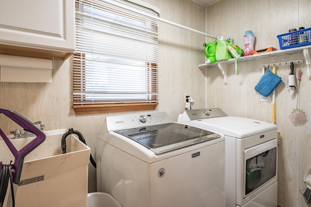 washroom with cabinets and washing machine and clothes dryer