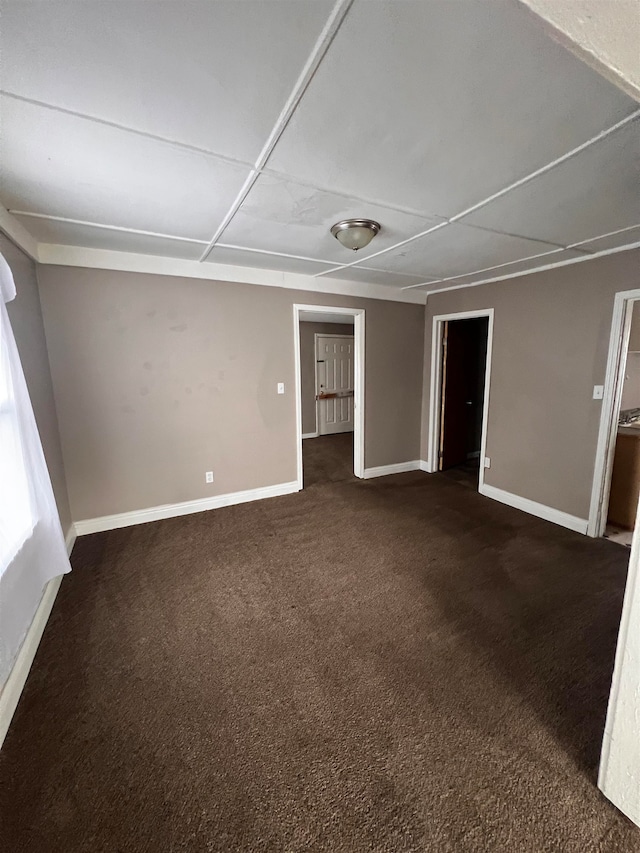 spare room featuring dark carpet