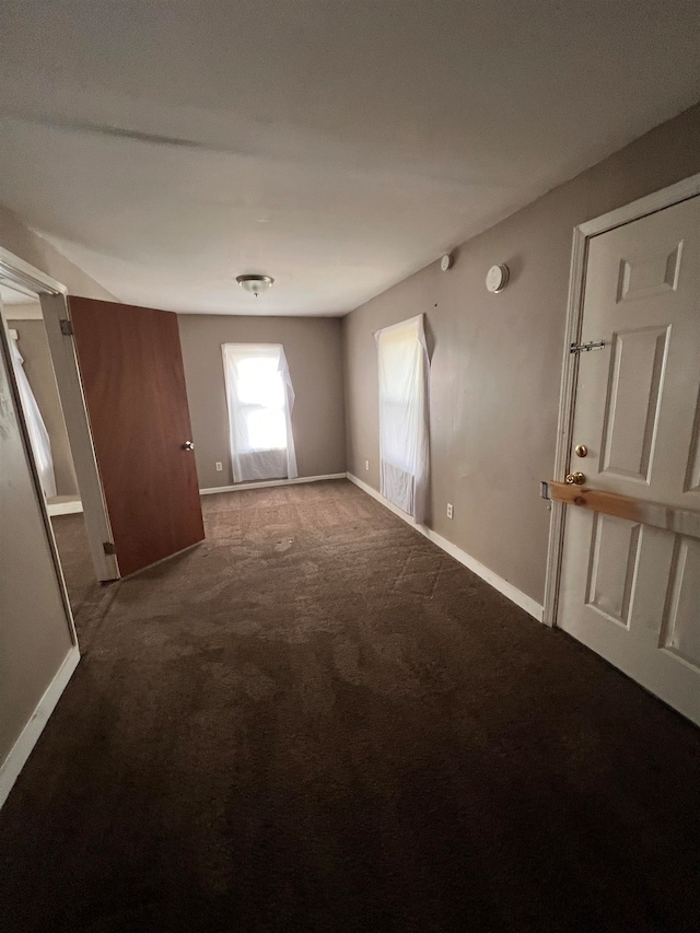 empty room with dark colored carpet