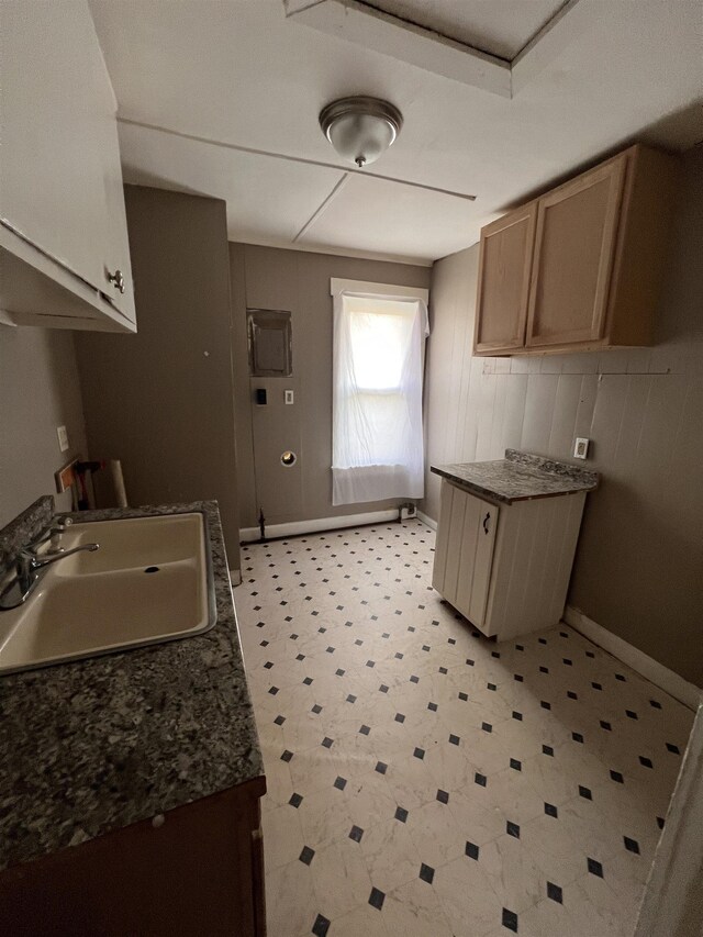 820 Vermilya Ave, Flint, MI 48507 - kitchen featuring a sink, light flooring, dark countertops, baseboards, and wood walls