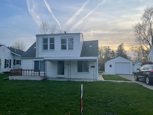 view of front of house featuring covered porch, a garage, an outdoor structure, and a yard