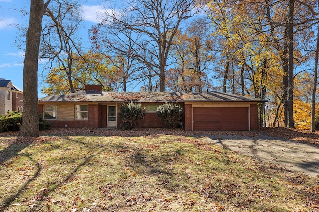 view of front facade featuring brick siding, a garage, driveway, and a chimney