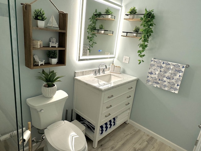 bathroom with toilet, vanity, and hardwood / wood-style flooring