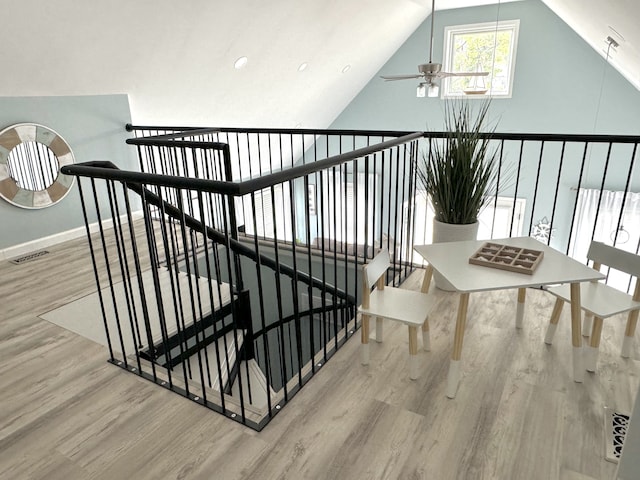 staircase featuring hardwood / wood-style flooring, vaulted ceiling, and ceiling fan