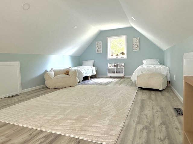 bedroom with light hardwood / wood-style floors and vaulted ceiling