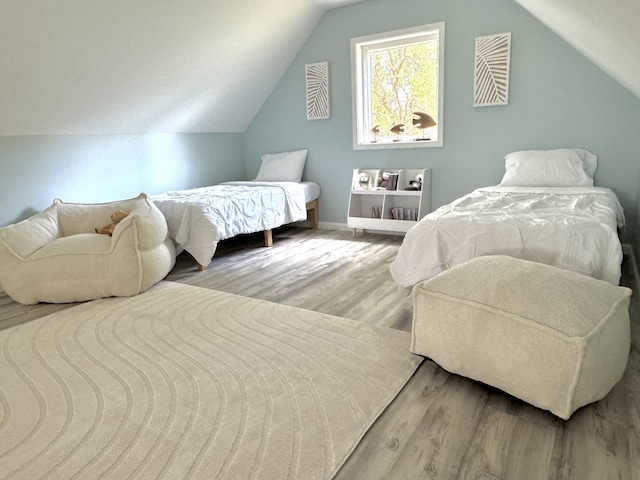 bedroom with lofted ceiling and light wood-type flooring