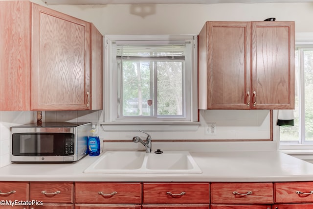 kitchen featuring decorative backsplash, a healthy amount of sunlight, and sink