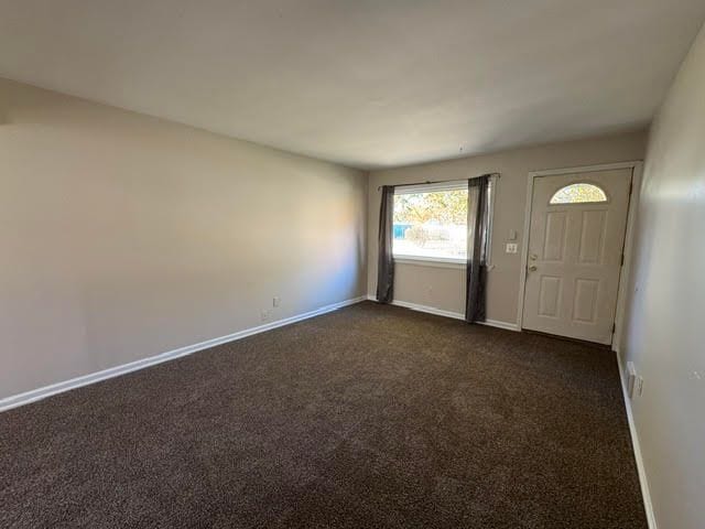 entrance foyer featuring dark colored carpet