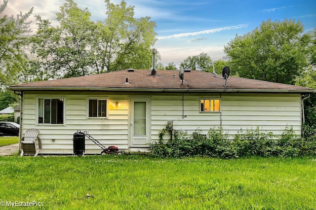 rear view of house featuring a lawn