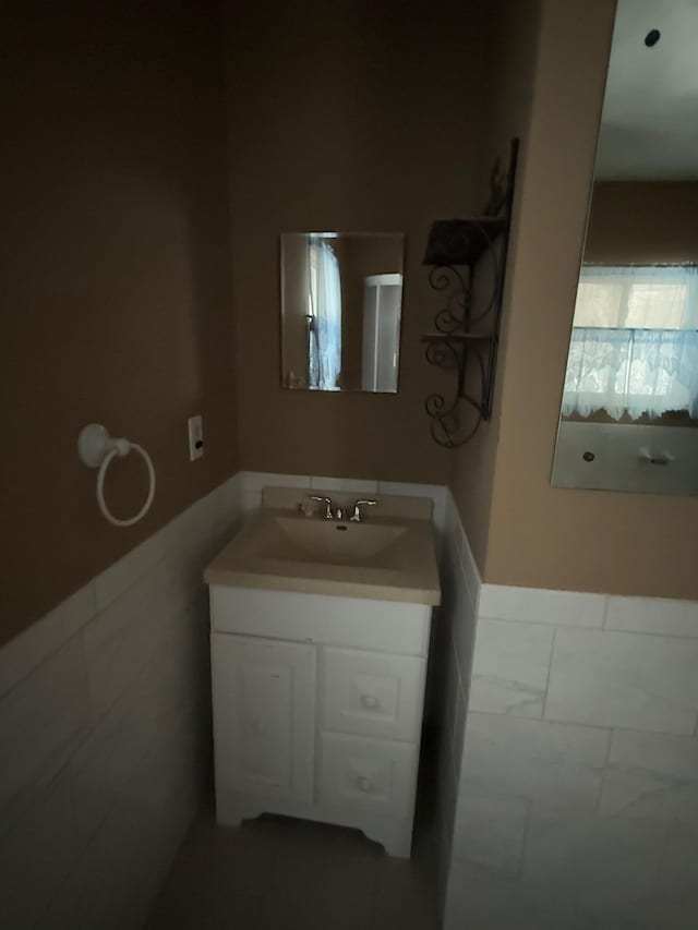 bathroom featuring vanity and tile walls