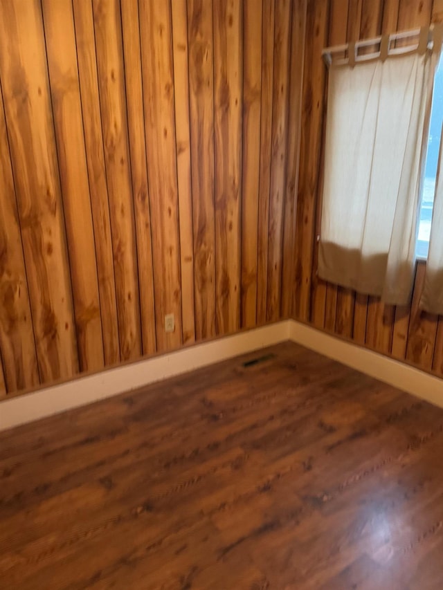 unfurnished room with dark hardwood / wood-style flooring