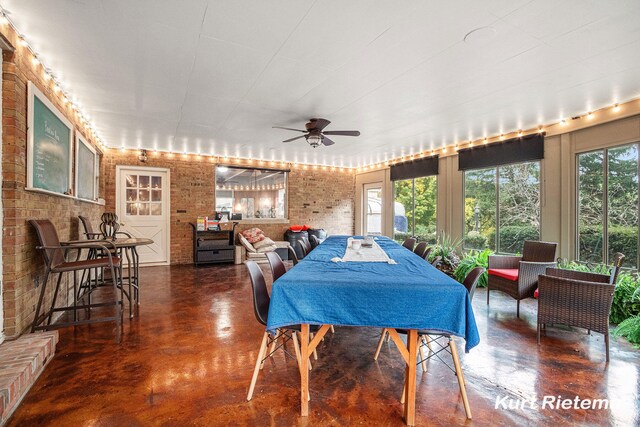 3205 Lakeshore Dr, Saint Joseph, MI 49085 - dining area featuring concrete flooring, brick wall, and a ceiling fan