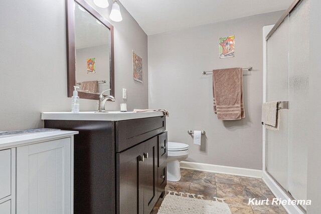 3205 Lakeshore Dr, Saint Joseph, MI 49085 - full bathroom featuring a stall shower, baseboards, stone finish floors, toilet, and vanity