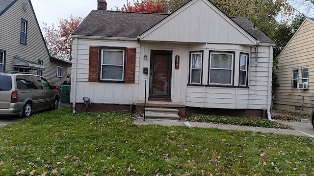 view of front of home featuring cooling unit and a front yard