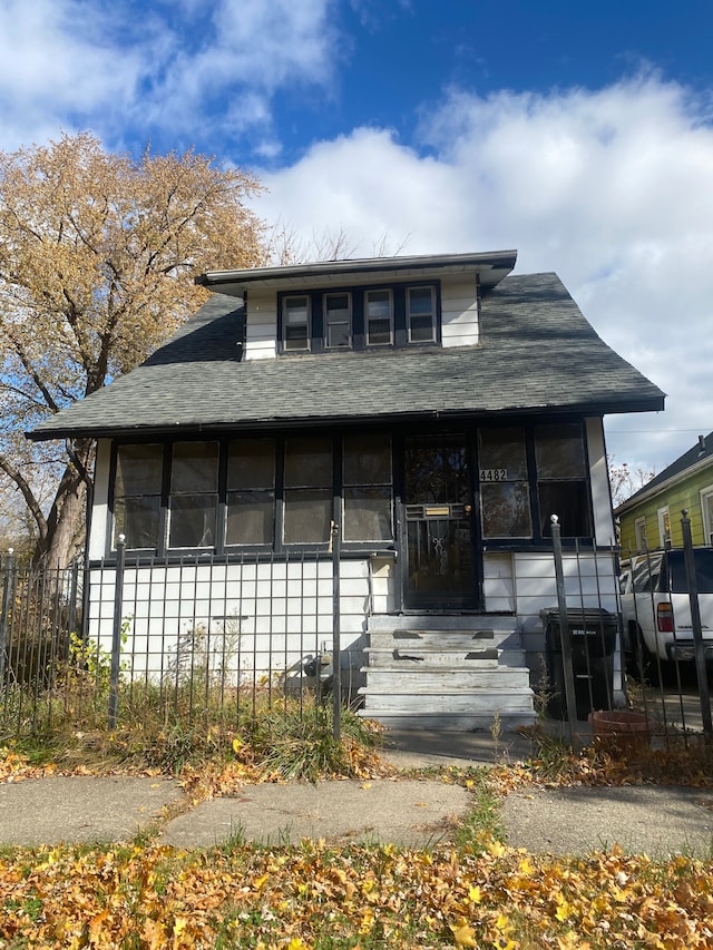 view of front of home featuring fence and roof with shingles