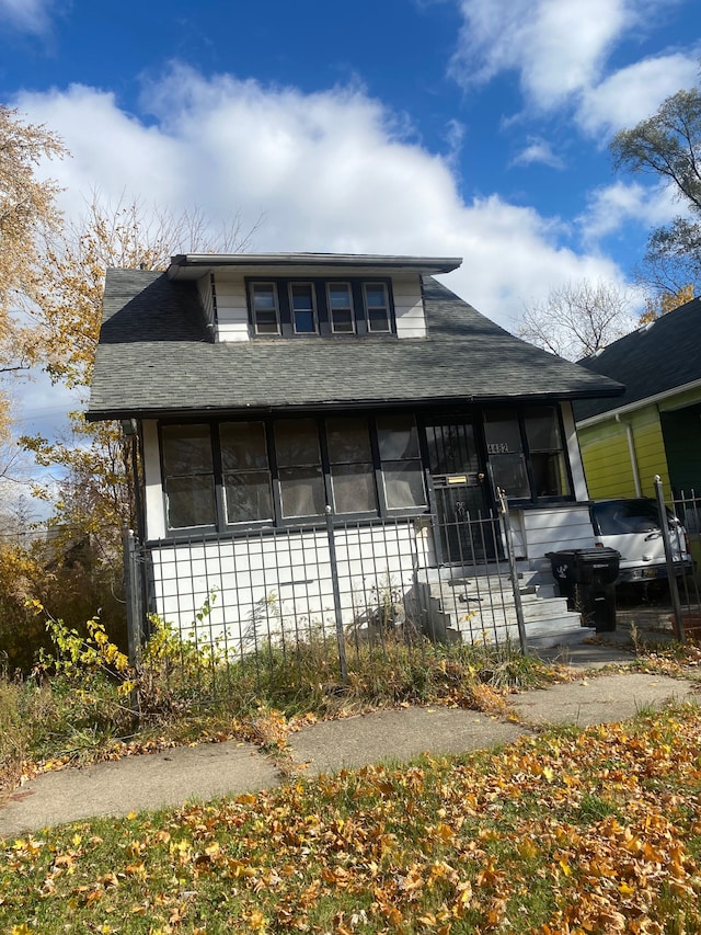 view of front facade with roof with shingles