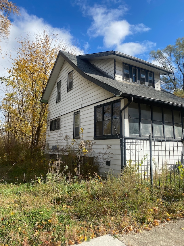 view of side of property featuring a shingled roof