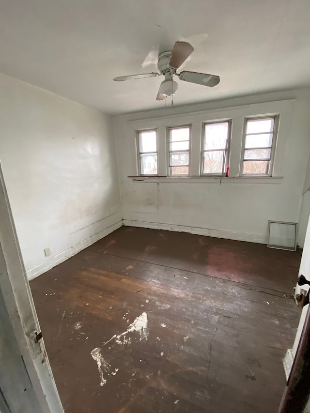 empty room with plenty of natural light, a ceiling fan, and baseboards