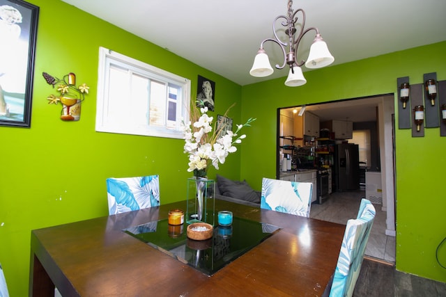 dining area featuring dark wood-type flooring and a notable chandelier