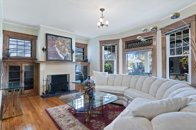 living room featuring a chandelier, crown molding, and wood-type flooring