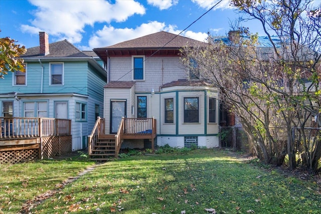 back of property with a lawn and a deck