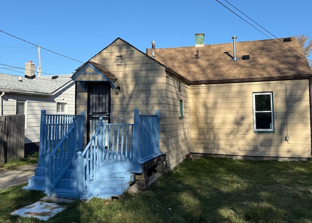 rear view of house featuring a yard