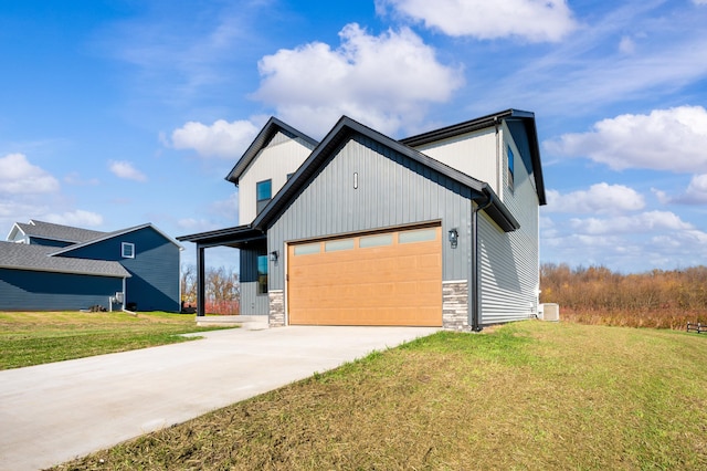 modern inspired farmhouse featuring a garage, a front yard, stone siding, and driveway