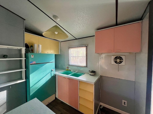 kitchen with sink, dark wood-type flooring, a textured ceiling, lofted ceiling, and fridge