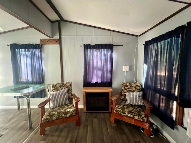 sitting room featuring hardwood / wood-style flooring, vaulted ceiling, ornamental molding, and wood walls