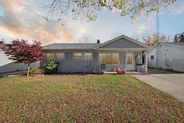 ranch-style house featuring a porch and a lawn