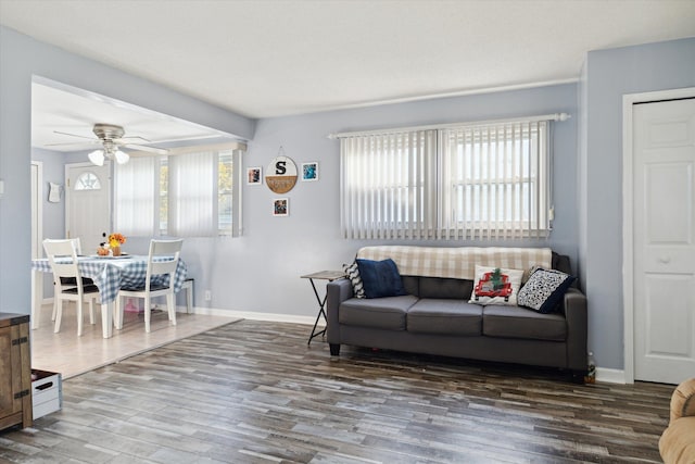 living room featuring ceiling fan and dark hardwood / wood-style flooring