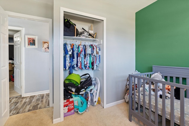 carpeted bedroom with a closet and a nursery area