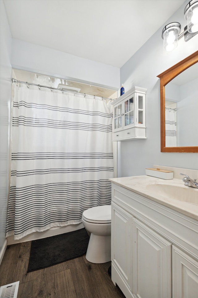 bathroom with vanity, hardwood / wood-style flooring, toilet, and walk in shower