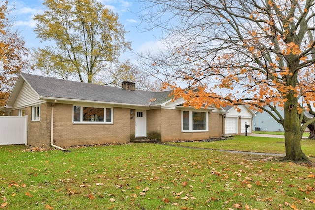 ranch-style home featuring a garage and a front lawn