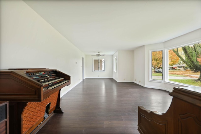 living room featuring ceiling fan and dark hardwood / wood-style floors