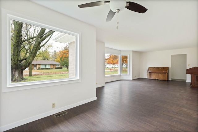 unfurnished living room with ceiling fan and dark wood-type flooring