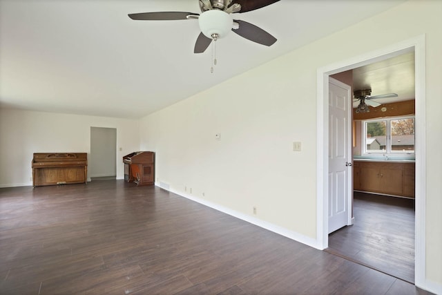 unfurnished living room featuring ceiling fan and dark wood-type flooring