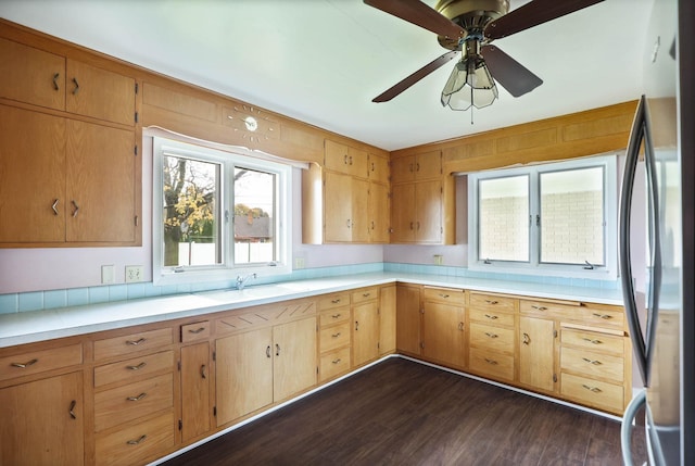 kitchen featuring ceiling fan, stainless steel fridge, dark hardwood / wood-style flooring, and sink