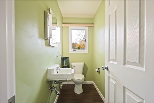 bathroom with hardwood / wood-style flooring and toilet