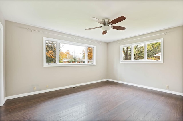 spare room featuring dark hardwood / wood-style flooring, a wealth of natural light, and ceiling fan