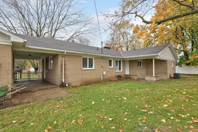 back of property featuring a yard, central AC, and a carport